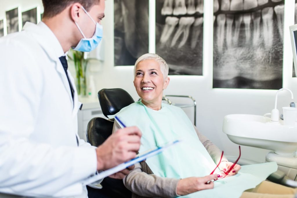 Dental professional and patient smiling at each other