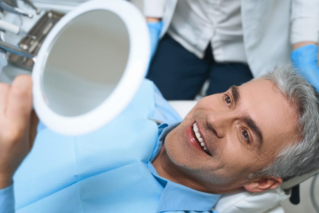 Patient smiling after getting supported fixed dental bridges